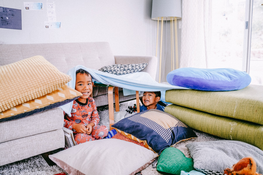 2 young boys under a pillow fort