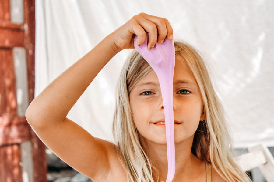young girl playing with pink slime