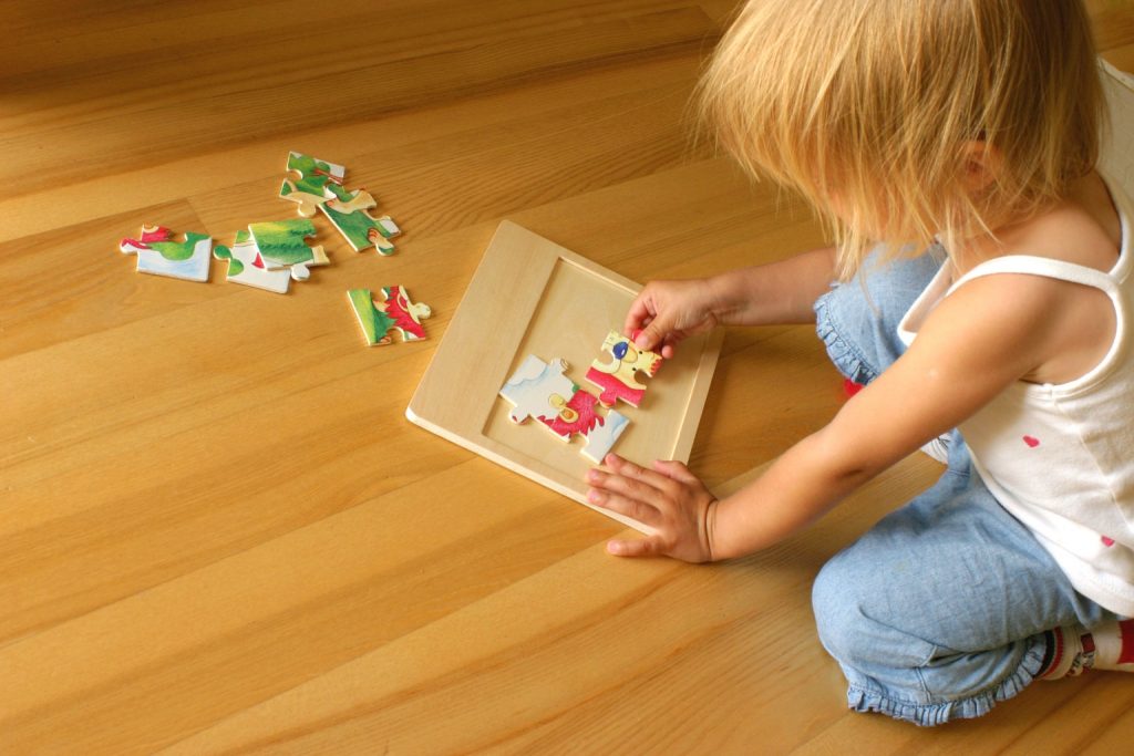 toddler making a puzzle on the floor