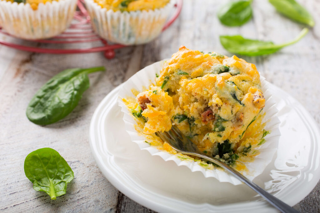 Spinach Goat Cheese and Sweet Potato Muffins on a plate with raw spinach